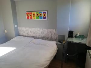 Ένα ή περισσότερα κρεβάτια σε δωμάτιο στο Hôtel Evan
