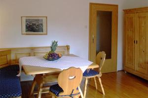 una mesa de comedor y sillas con un bol de fruta. en Sporerhof en Murnau am Staffelsee