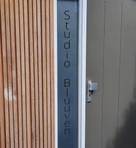 ein Schild an der Seite eines Gebäudes in der Unterkunft Studio Bluuven in Scharendijke