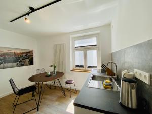 a kitchen with a table and a counter top at HafenCity Appartements Stralsund in Stralsund