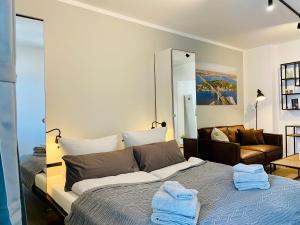 a bedroom with a large bed with towels on it at HafenCity Appartements Stralsund in Stralsund