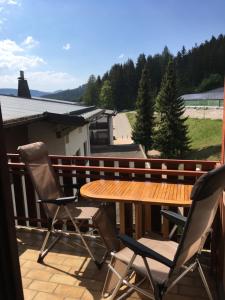 a wooden table and two chairs on a balcony at Zu Hause am See - Pool, Sauna, Fitnessraum in Schluchsee