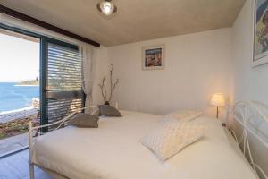 1 dormitorio con 1 cama y vistas al océano en House on Punta en Vela Luka