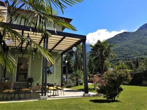 a house with a patio with tables and chairs at Residenza Laurum B&B in Mandello del Lario