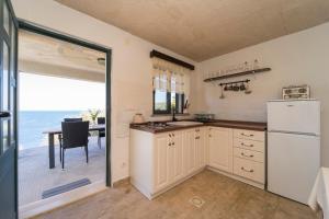 cocina con nevera y mesa con vistas al océano en House on Punta, en Vela Luka