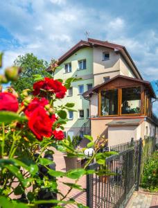 un edificio con una rosa roja delante de él en Zacisze Sosnowe, en Łazy