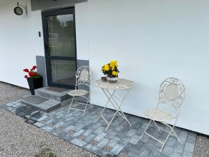 a table and two chairs sitting next to a building at Cazare For-Rest Accommodation in Baraolt