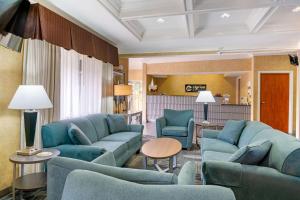 梅德福的住宿－Clarion Pointe Medford，客厅配有蓝色的沙发和椅子