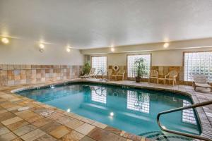 a large swimming pool with chairs and a table at Clarion Pointe Medford in Medford