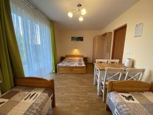 Habitación con 2 camas, mesa y 1 dormitorio. en Toskania Pokoje Goscinne en Karwia