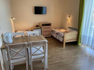 una habitación con mesa y sillas y un dormitorio en Toskania Pokoje Goscinne en Karwia