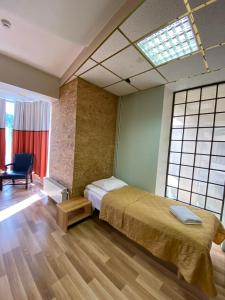 een slaapkamer met een bed, een stoel en ramen bij Majaka Hostel in Tallinn