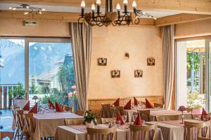 un comedor con mesas y sillas en una habitación en Hôtel Le Christania, en Bellevaux