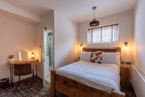 1 dormitorio con cama, escritorio y ventana en Palace Hill Hotel en Scarborough