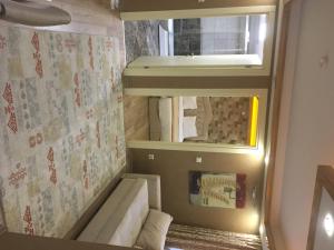 Habitación pequeña con sofá y espejo. en Best Fulya Suites, en Estambul
