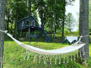 a hammock in front of a tree house at Tree house Linde in Kaibala