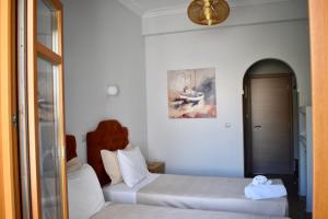 una camera con due letti e un dipinto sul muro di Minoa Hotel a Naoussa