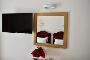 uno specchio a parete accanto a un letto di Minoa Hotel a Naoussa