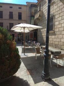 an outdoor patio with a table and an umbrella at Casa Turística Plaza del Conde in Ciudad-Rodrigo