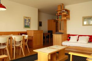 1 dormitorio con 1 cama y comedor con mesa en Skilifts & Central | Palma A en Crans-Montana