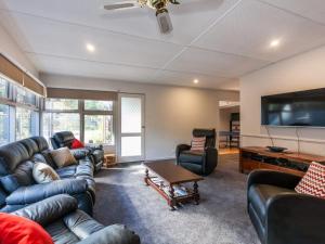a living room with couches and a flat screen tv at Oceans 12 in Anglesea