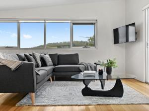 una sala de estar con un sofá y una mesa en Surf Central, en Lorne