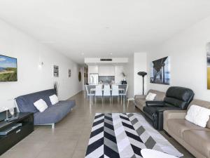 a living room with couches and a dining room at Waterfront Three in Lorne