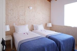two beds in a room with blue and white sheets at Monte Velho Retreat Centre in Aljezur +88 photos