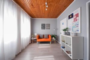 una sala de estar con una silla naranja y una ventana en Blue Door Lagos, en Lagos