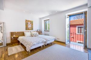 a bedroom with a bed and a large window at Vila Libania in Queluz