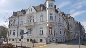 a large white building on the corner of a street at Andrés Ferienwohnung DELUXE in Cottbus