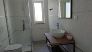 a white bathroom with a sink and a shower at Irena in Cres