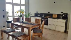 a kitchen with a wooden table and a table and chairs at Andrés Ferienwohnung DELUXE in Cottbus