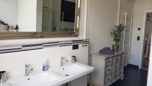 a bathroom with two sinks and a mirror at Andrés Ferienwohnung DELUXE in Cottbus +16 photos