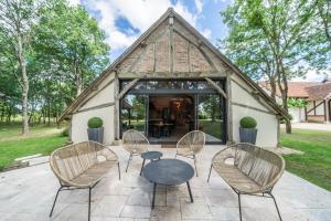 un gruppo di sedie e un tavolo su un patio di La Grange De Léonie, Chambres d'hôtes avec Piscine et Spa a Méry-sur-Cher