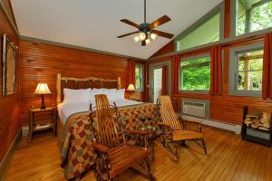 a bedroom with a bed and a table and chairs at Friends Lake Inn in Chestertown