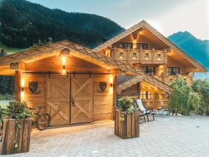 ein großes Holzgebäude mit großer Garage in der Unterkunft Hotel Vermala in Sankt Gallenkirch