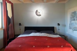 een slaapkamer met een bed met een rode deken bij Ferienwohnung Waldmeister in Sankt Peter