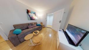 a living room with a couch and a flat screen tv at 70 m² Strasbourg Appart city center in Strasbourg