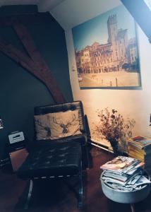 uma cadeira preta num quarto com uma fotografia em B&B Het Rode Hert em Doesburg