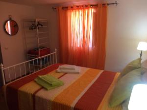 a bedroom with a bed with two towels on it at Cerro da Janela Hostel in Alte