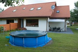 a house with a large trampoline in the yard at Apartamenty Julia in Szteklin