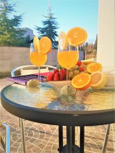 zwei Gläser Orangensaft auf einem Tisch mit Obst in der Unterkunft A.B.Kvarner in Rijeka