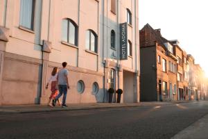 un hombre y una mujer caminando por una calle en Hotel Adoma en Gante