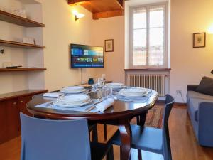 a dining room with a table with chairs and a tv at Downtown Varenna - Historic Centre by villavistalago in Varenna