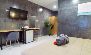 a room with a tv on a wall with chairs at Paradise Land Resort in North Pattaya