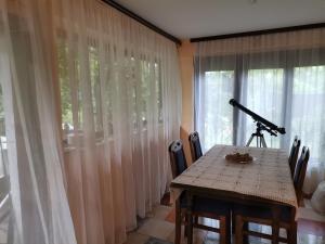 a table with a telescope in a room with curtains at Zavojsko jezero Pirot - smestaj Manic in Gostuša