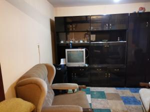 a living room with a couch and a tv at Zavojsko jezero Pirot - smestaj Manic in Gostuša