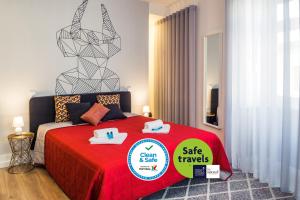 um quarto com uma cama vermelha com um sinal de venda em In Barcelos Hostel & Guest House em Barcelos