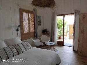 - une chambre avec un lit, une table et des chaises dans l'établissement Centre Cap-ferret, les chambres du phare, océan, à Bélisaire